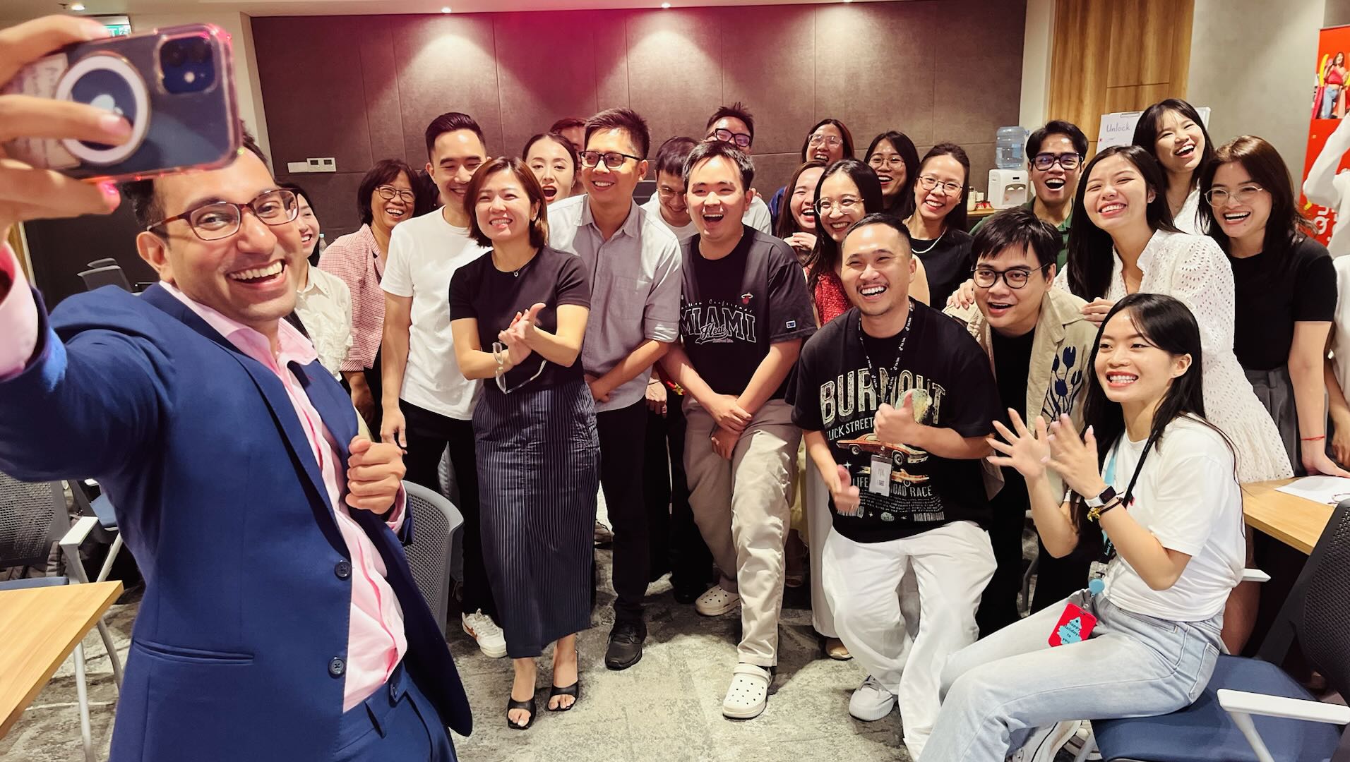 Akash Karia taking a selfie with a corporate team after a high-energy motivational workshop in the Philippines, everyone laughing and engaged