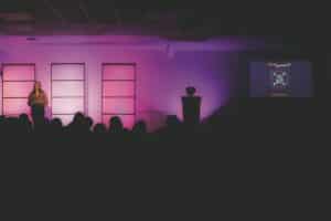 Inspirational speaker on stage at a corporate conference in the Philippines with purple stage lighting
